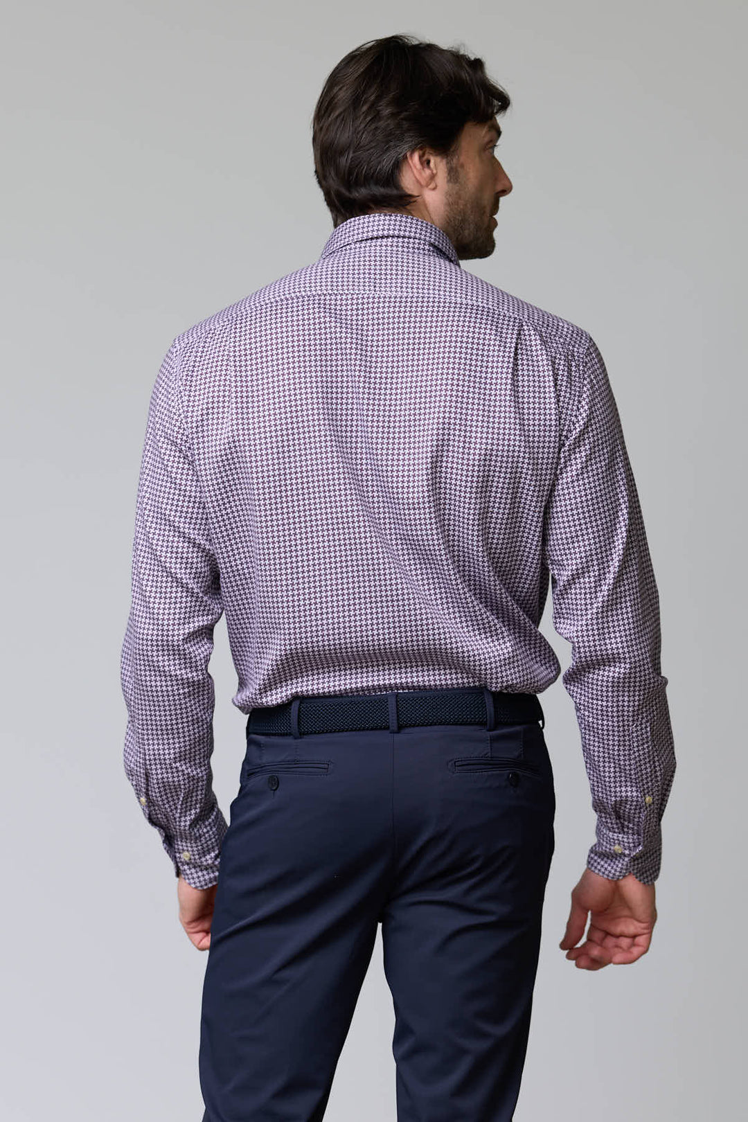 Homme portant une chemise à motif géométrique à manches longues, vue de dos, avec une coupe ajustée et un col semi-rigide.