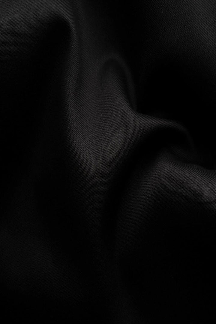 Tissu noir en twill, texture fluide et élégante, idéal pour une chemise intemporelle.