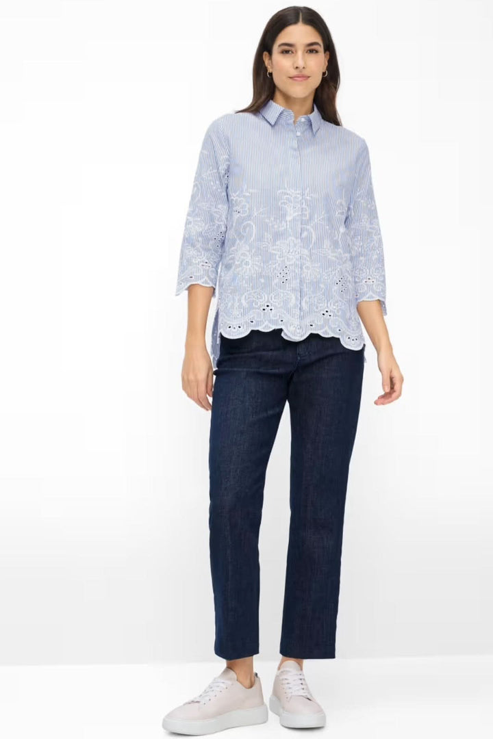 Femme portant la chemise rayé Vicki avec broderie, coupe droite fluide, col classique et manches trois-quarts, look élégant et féminin.