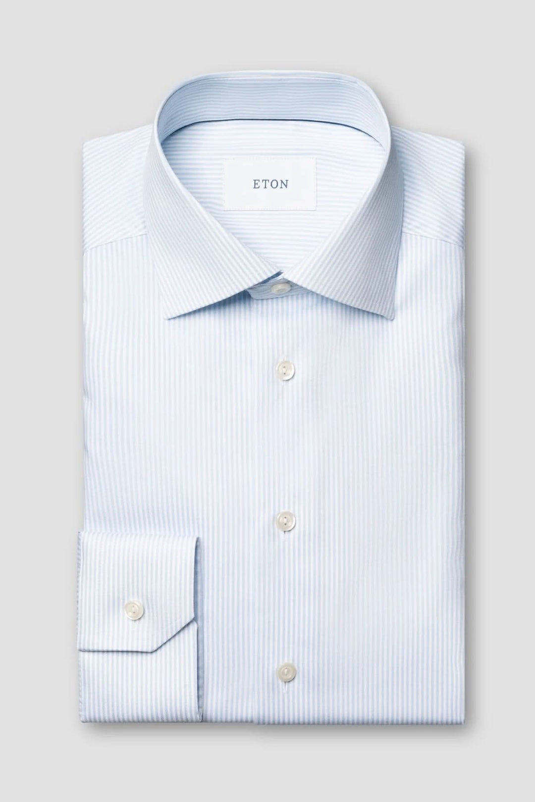 Chemise rayée en coton et lyocell avec fines rayures bleues, col italien structuré, élégante et adaptée pour usage quotidien ou professionnel.