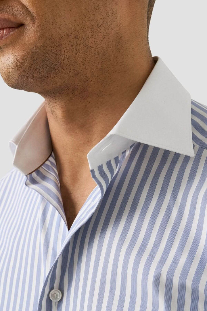 Homme portant une chemise à rayures Bengal à col blanc, élégante et ajustée, idéale pour un look professionnel raffiné.