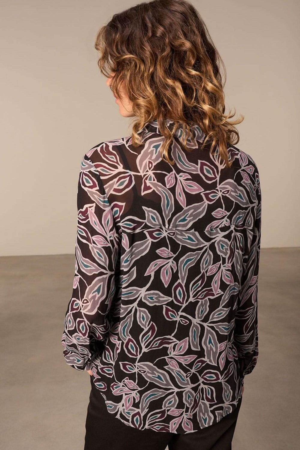 Chemise semi transparente à imprimé floral, dos visible, manches longues, style chic et féminin.