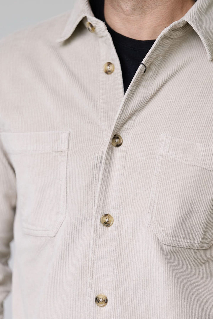 Chemise sport en velours côtelé style surchemise avec poches avant, col structuré et boutons contrastants.
