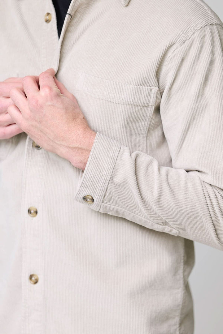 Homme portant une chemise sport en velours côtelé style surchemise avec une main sur la poitrine.