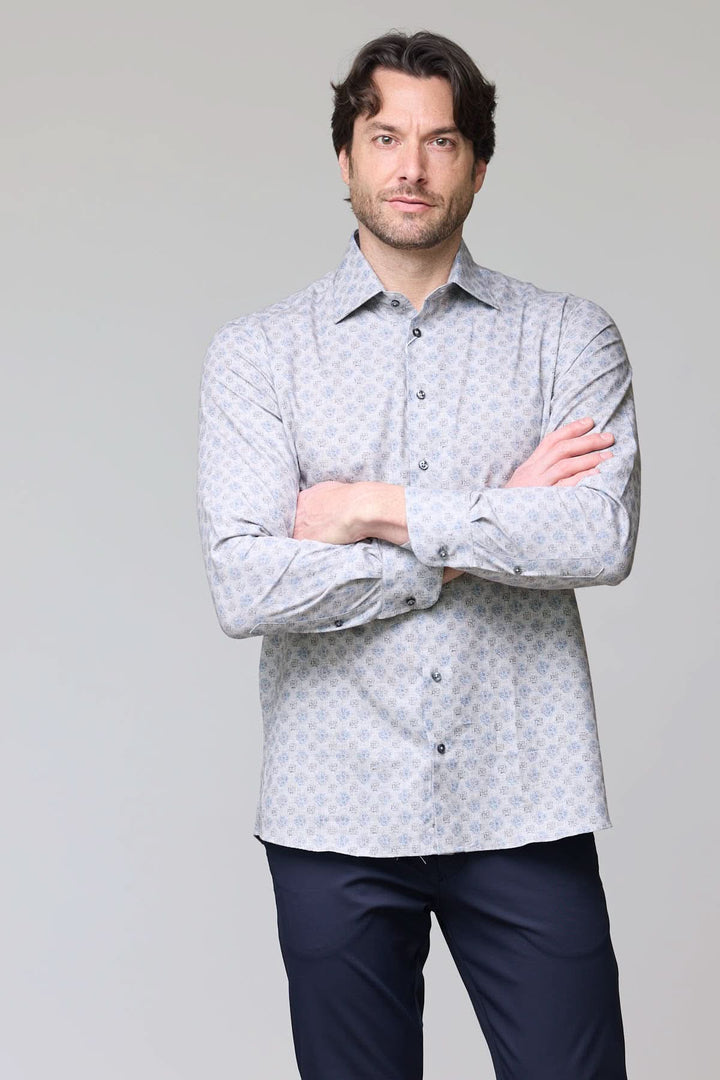 Homme portant une chemise sport à motif géométrique bleu pâle avec boutons contrastants, tenue élégante et moderne.