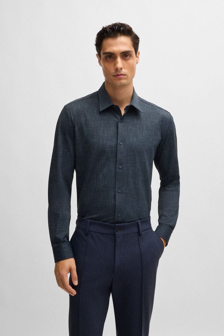 Chemise BOSS à imprimé moderne, tissu extensible, coupe étroite, portée par un homme en pantalon.