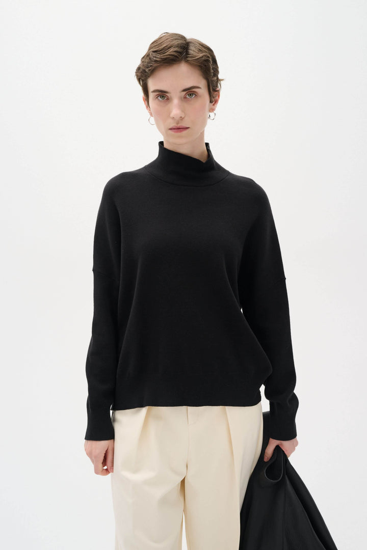 Col roulé Tenley en coton noir, design épuré avec manches longues et épaules tombantes, look décontracté et soigné.