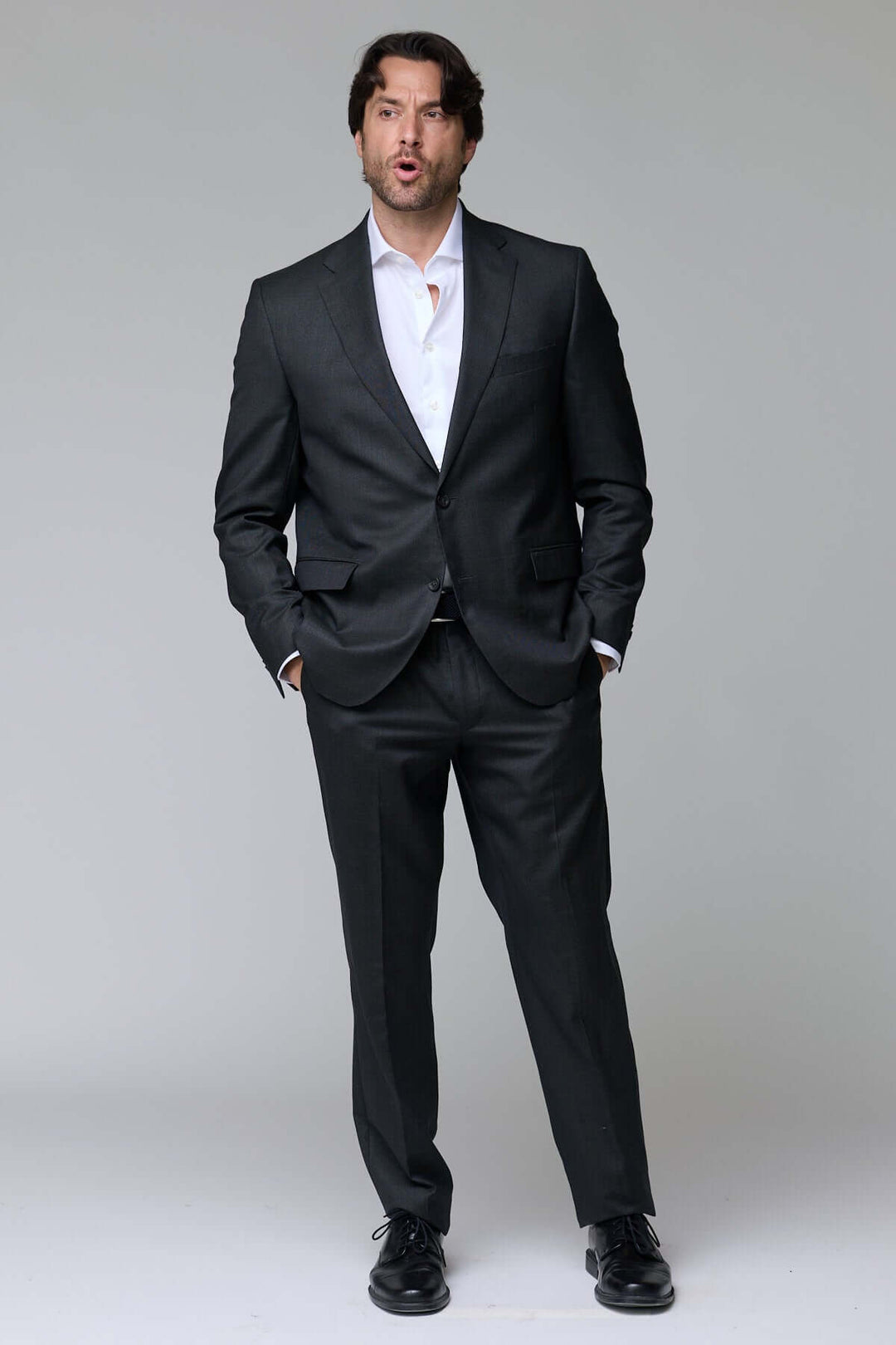 Homme portant un complet classique deux pièces élégant et ajusté, idéal pour événements et bureau. Décris moi le produit en français.