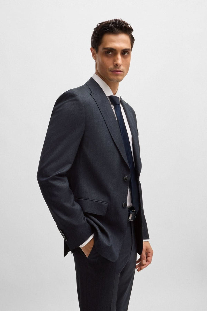 Homme en complet slim à micro-motifs, élégant et moderne, avec veste structurée et cravate.