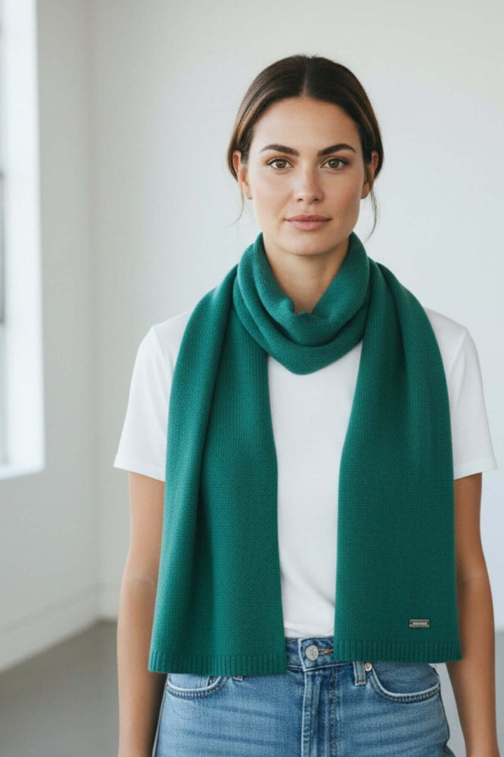 Femme portant un foulard doux essentiel vert émeraude, drapé élégamment autour du cou, idéal pour une touche raffinée quotidienne.