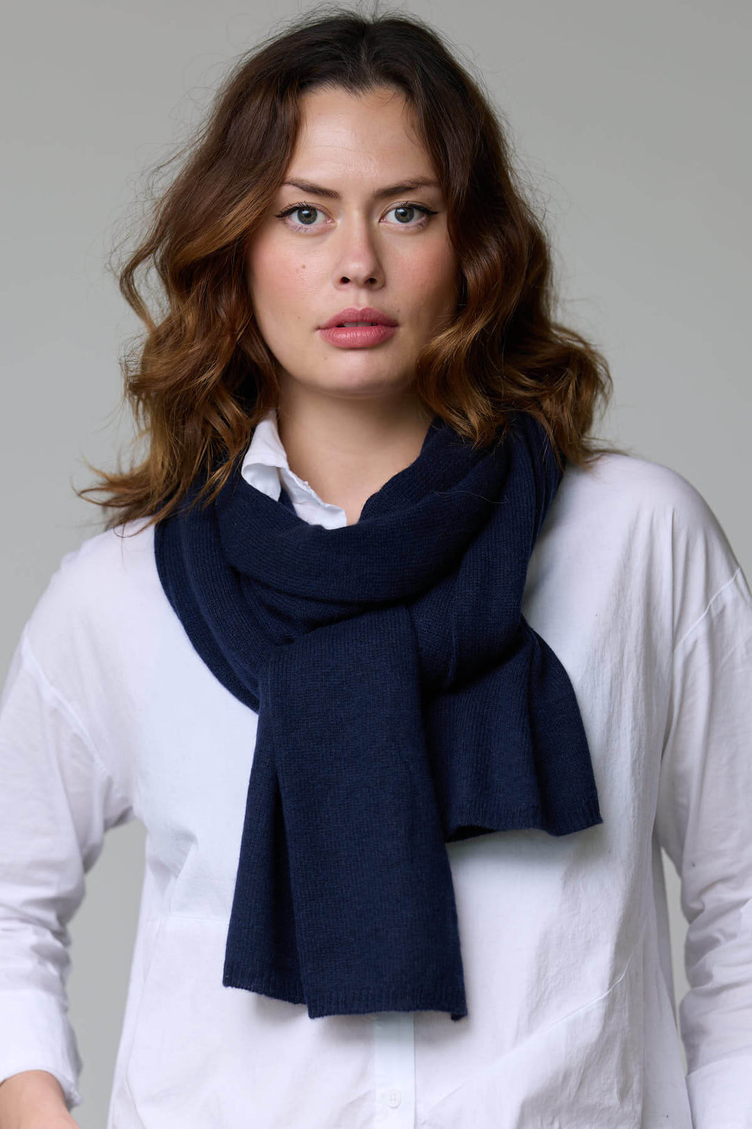 Foulard en laine bleu marine autour du cou, mélange luxueux de laine et cachemire, parfait pour tenues automnales et hivernales.