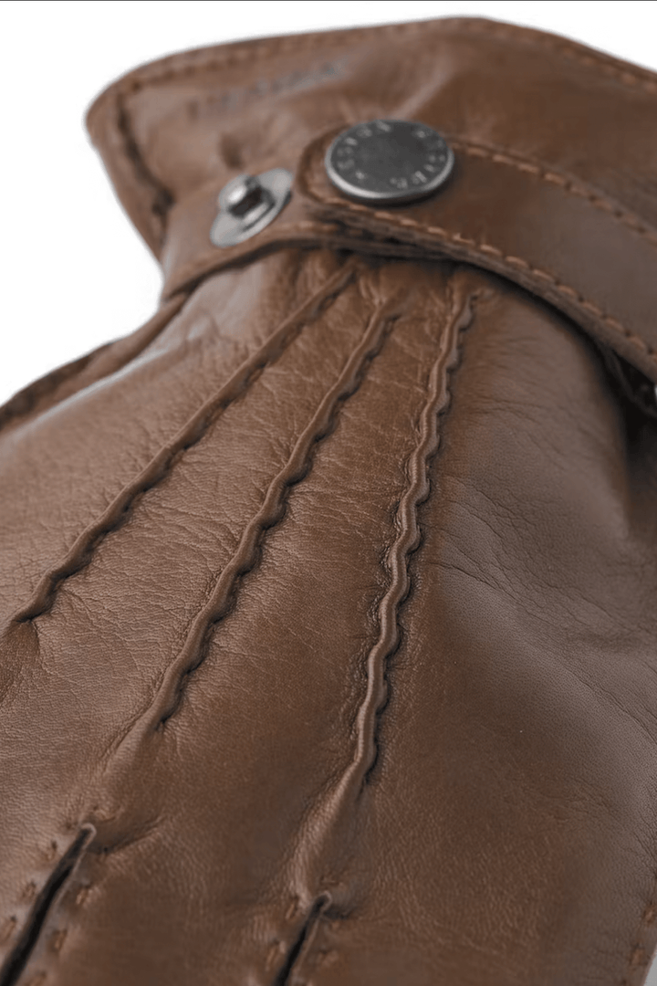 Détails en gros plan des gants de cuir Jake en nappa d'agneau italien marron avec bouton-pression.