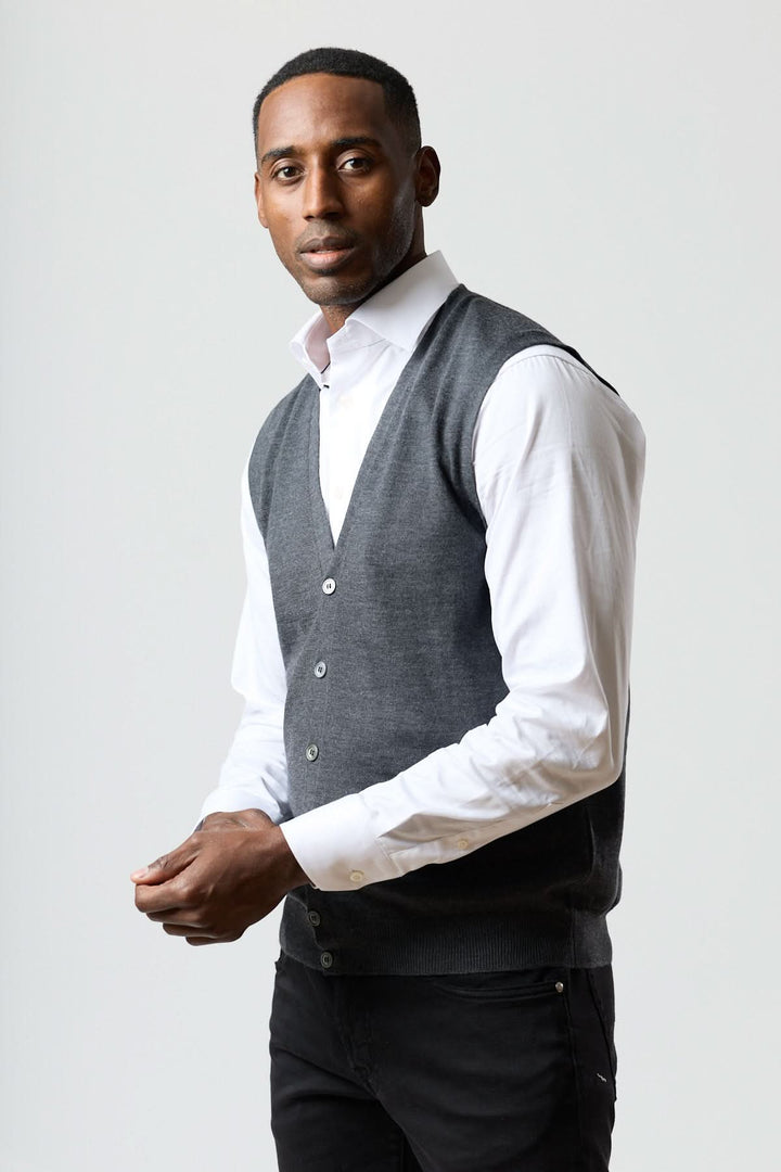 Homme portant un gilet en laine mérinos à col en V sur une chemise blanche, style élégant et moderne, savoir-faire italien.