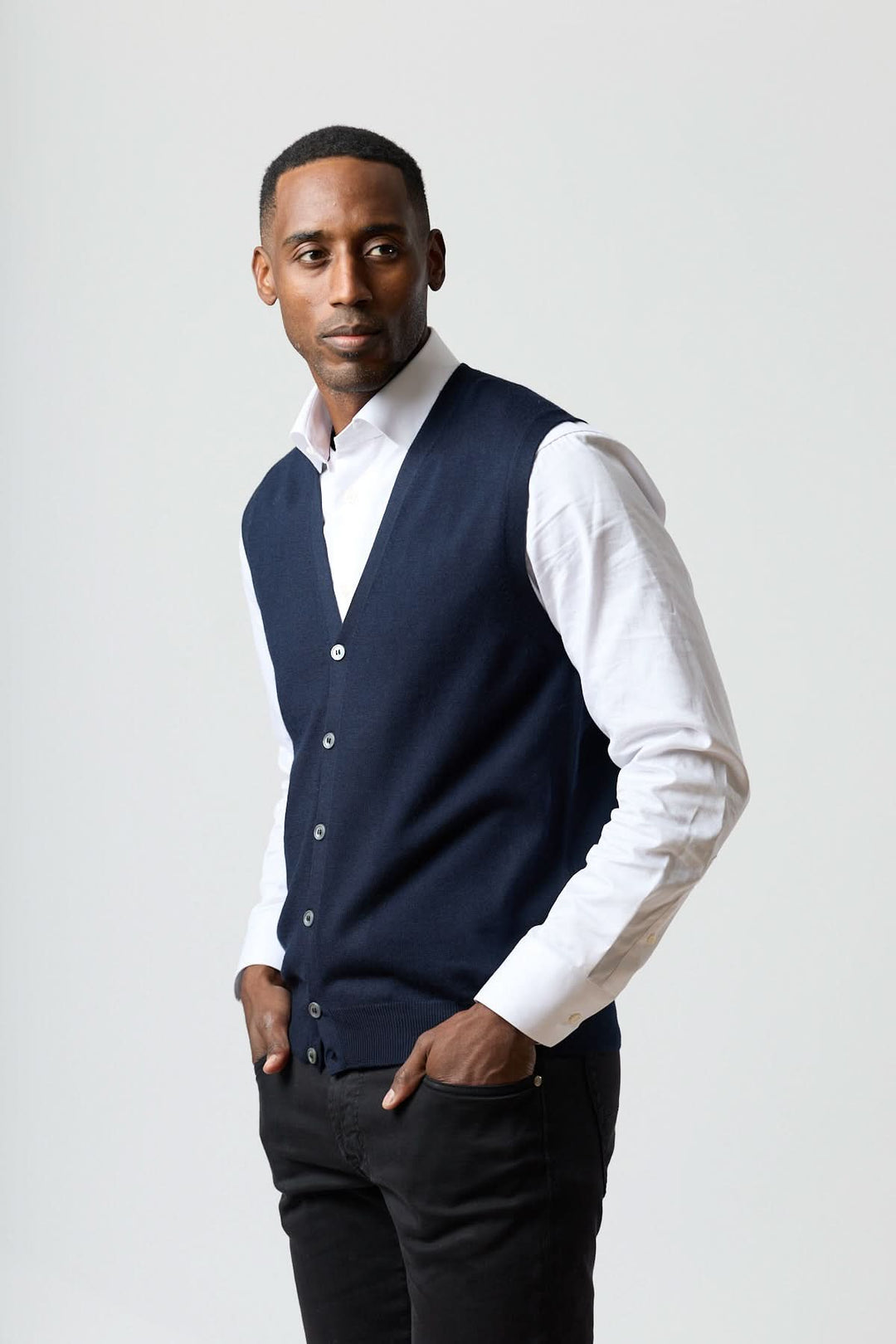 Homme portant un gilet en laine mérinos à col en V, coupe ajustée et élégante, parfait pour un look raffiné et intemporel.