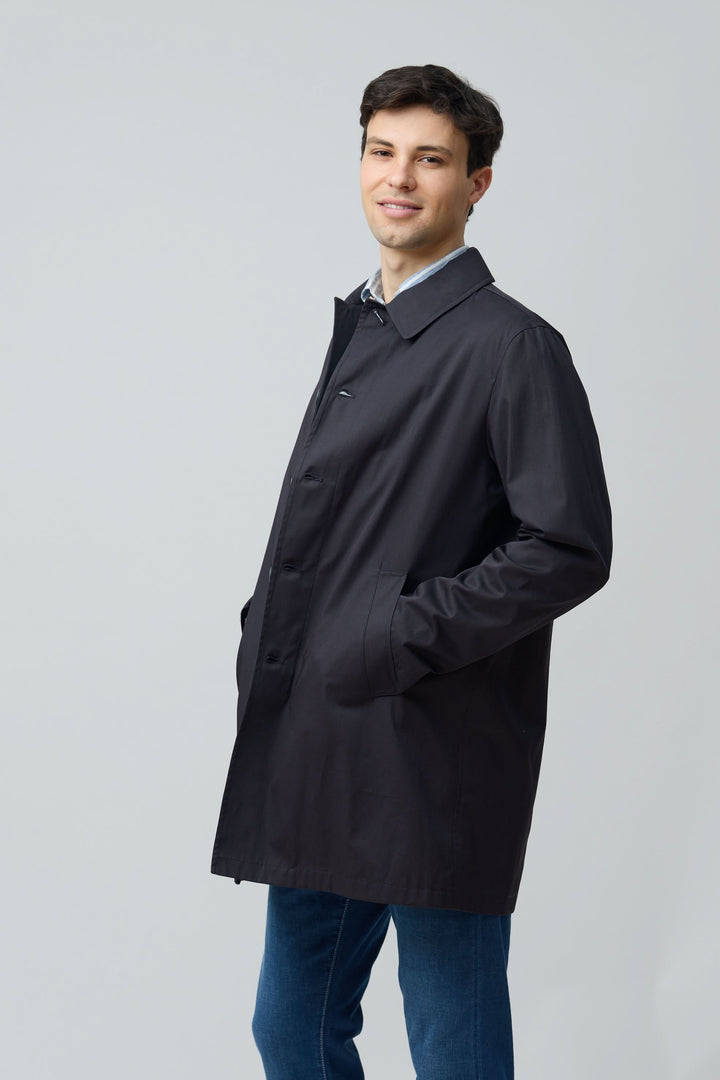 Homme portant un impermeable en gabardine de coton élégant et fonctionnel, idéal pour les journées urbaines.