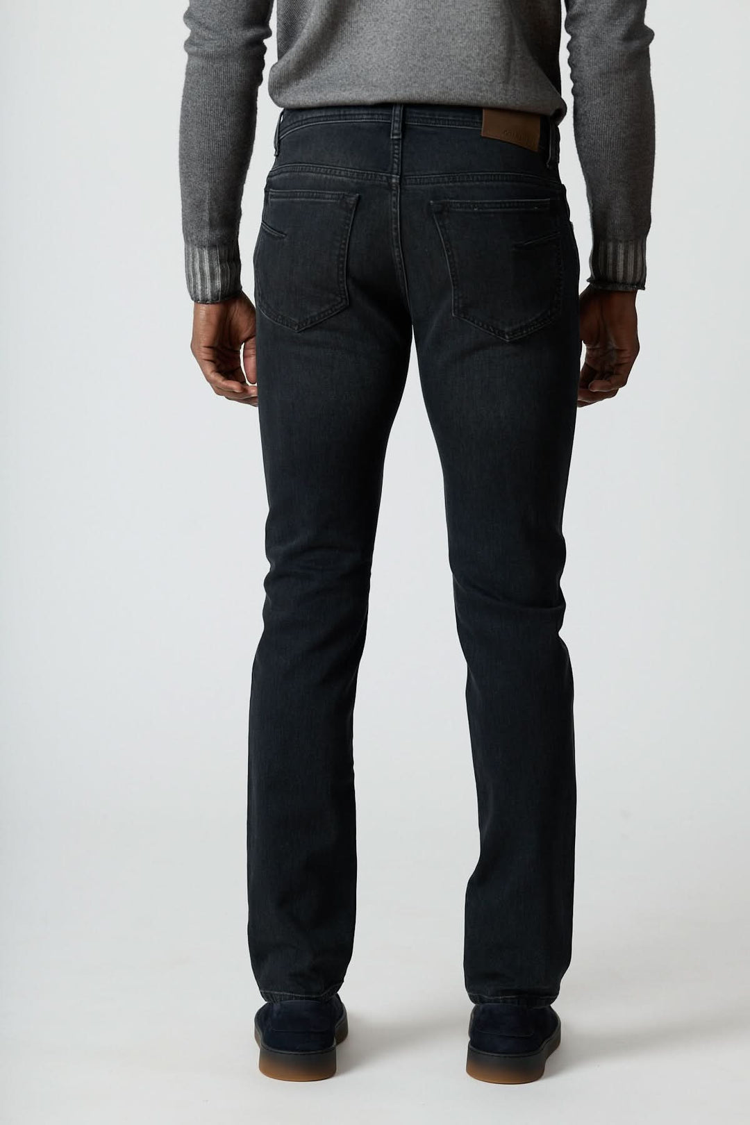 Homme portant un Jean 5 poches en denim stretch gris foncé, coupe ajustée vue de dos, style moderne avec confort durable.