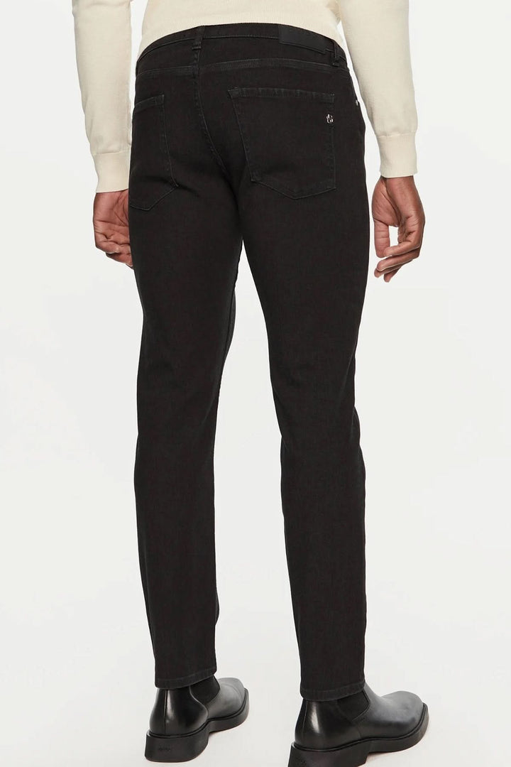 Homme portant des jeans noirs slim fit de BOSS, vus de dos, pour un look élégant et confortable.