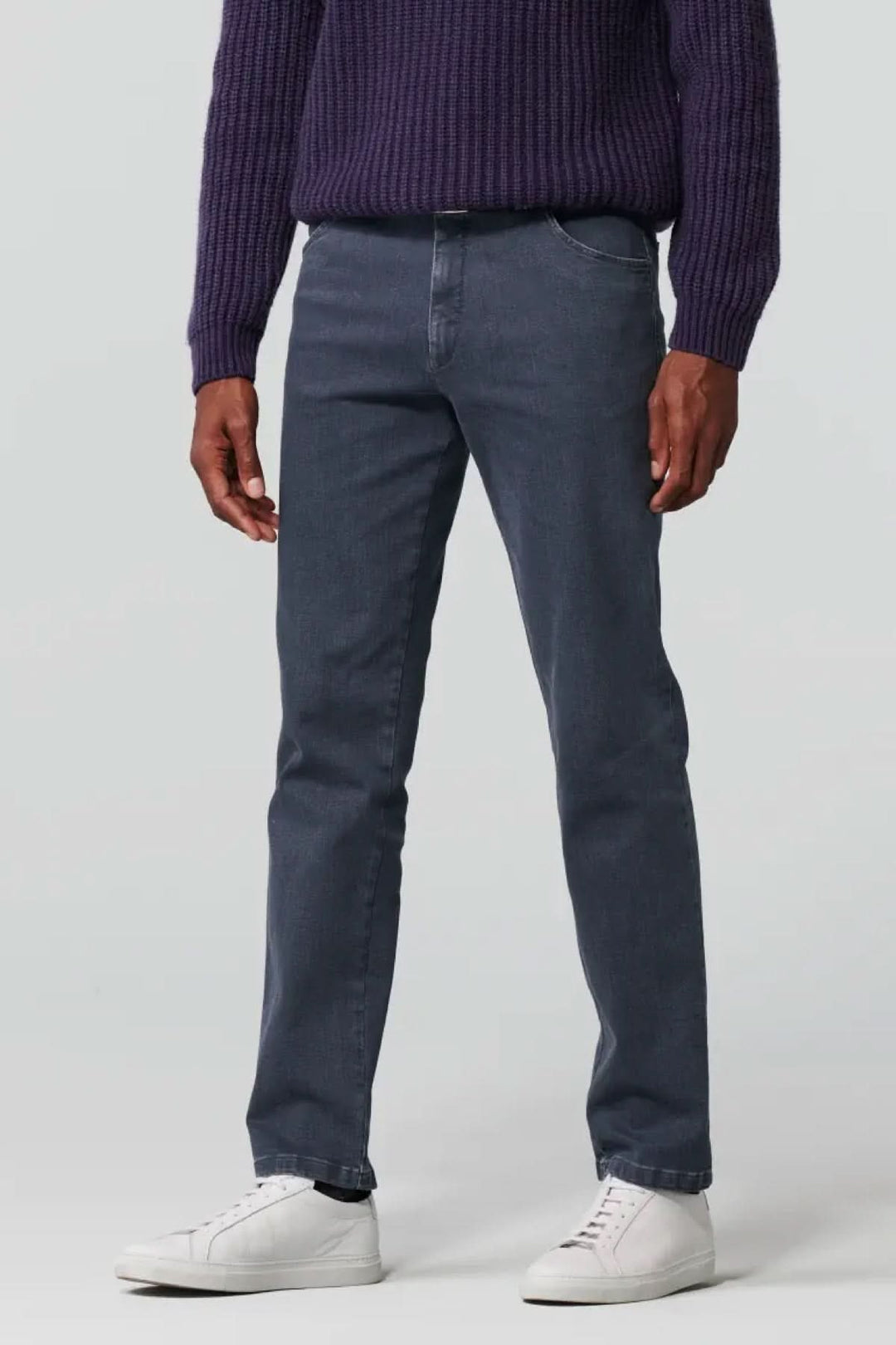 Jean slim en denim biologique gris, offrant confort et liberté de mouvement, associé à un pull violet.