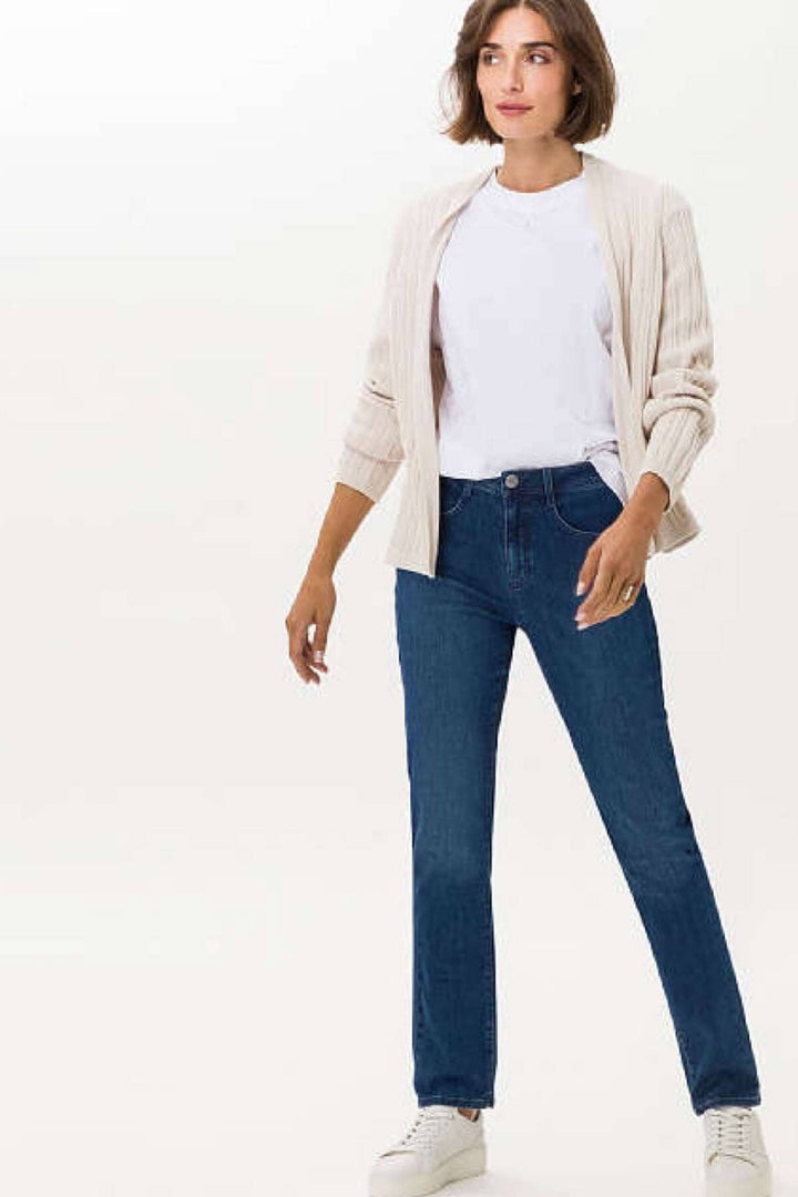 Femme portant le jean classique MARY, style décontracté avec t-shirt blanc et cardigan, sneakers blanches.