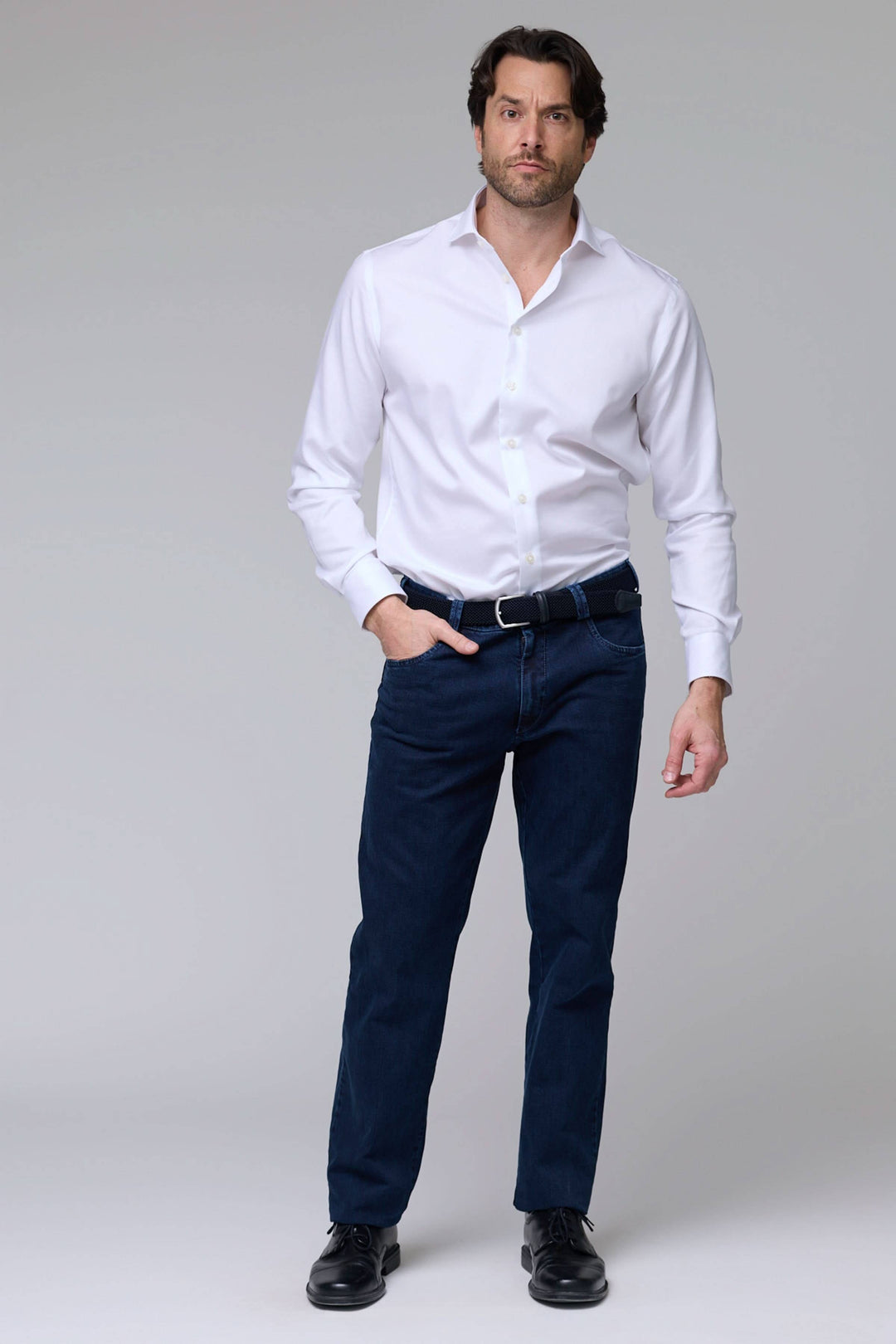 Homme portant un jean coupe droite avec chemise blanche, style moderne et confort pour tous les jours. Jean coupe droite élégant.