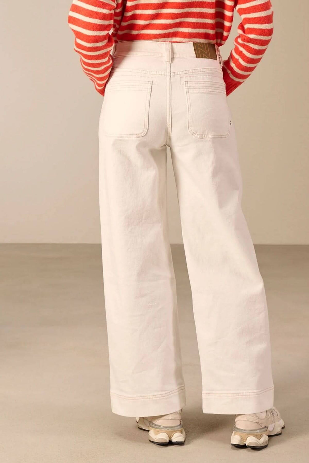 Vue arrière d'un jean jambe large blanc avec poches, taille haute, confort moderne. Parfait pour un style décontracté et soigné.