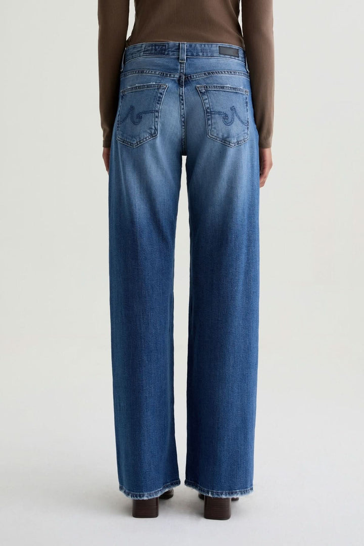 Jean à jambe large en denim délavé moyen, coupe ample et confortable, vue arrière.