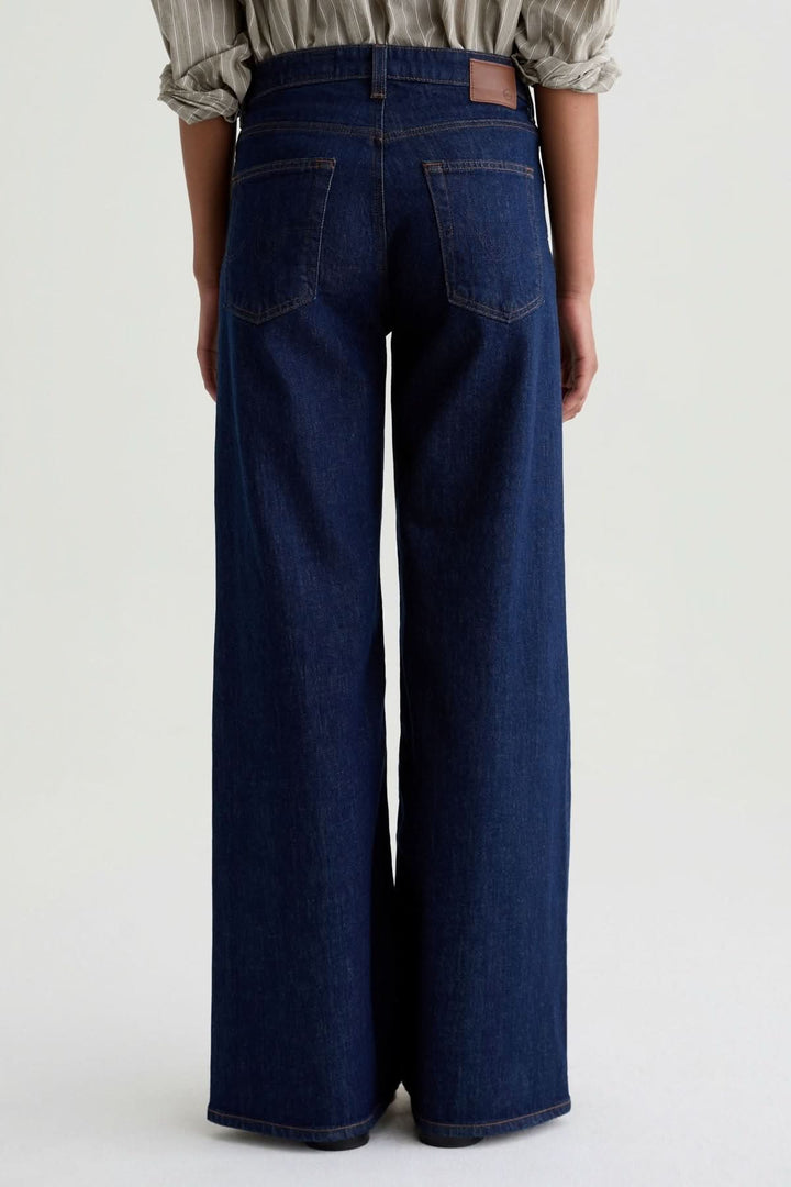 Jean à jambe large, denim classique à taille haute, vue arrière, coupe fluide, mode élégante et décontractée.