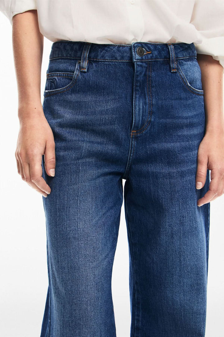 Jean ample à taille régulière en denim bleu, parfait pour un style décontracté et féminin.