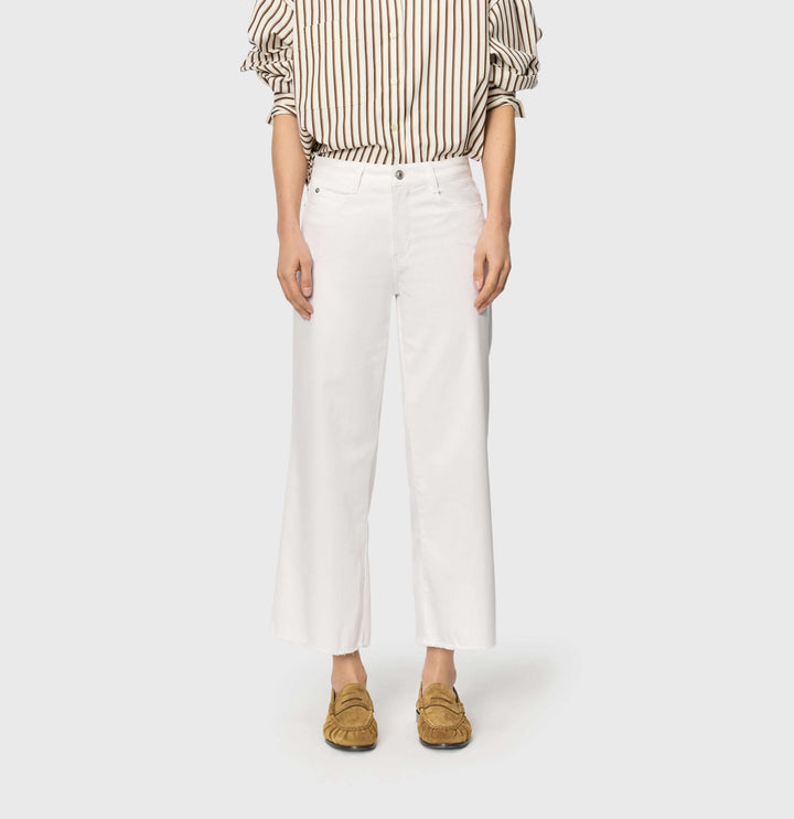 Jeans léger Dream wide cropped blanc à jambe large et taille mi-haute, porté avec une chemise rayée et des mocassins marron.