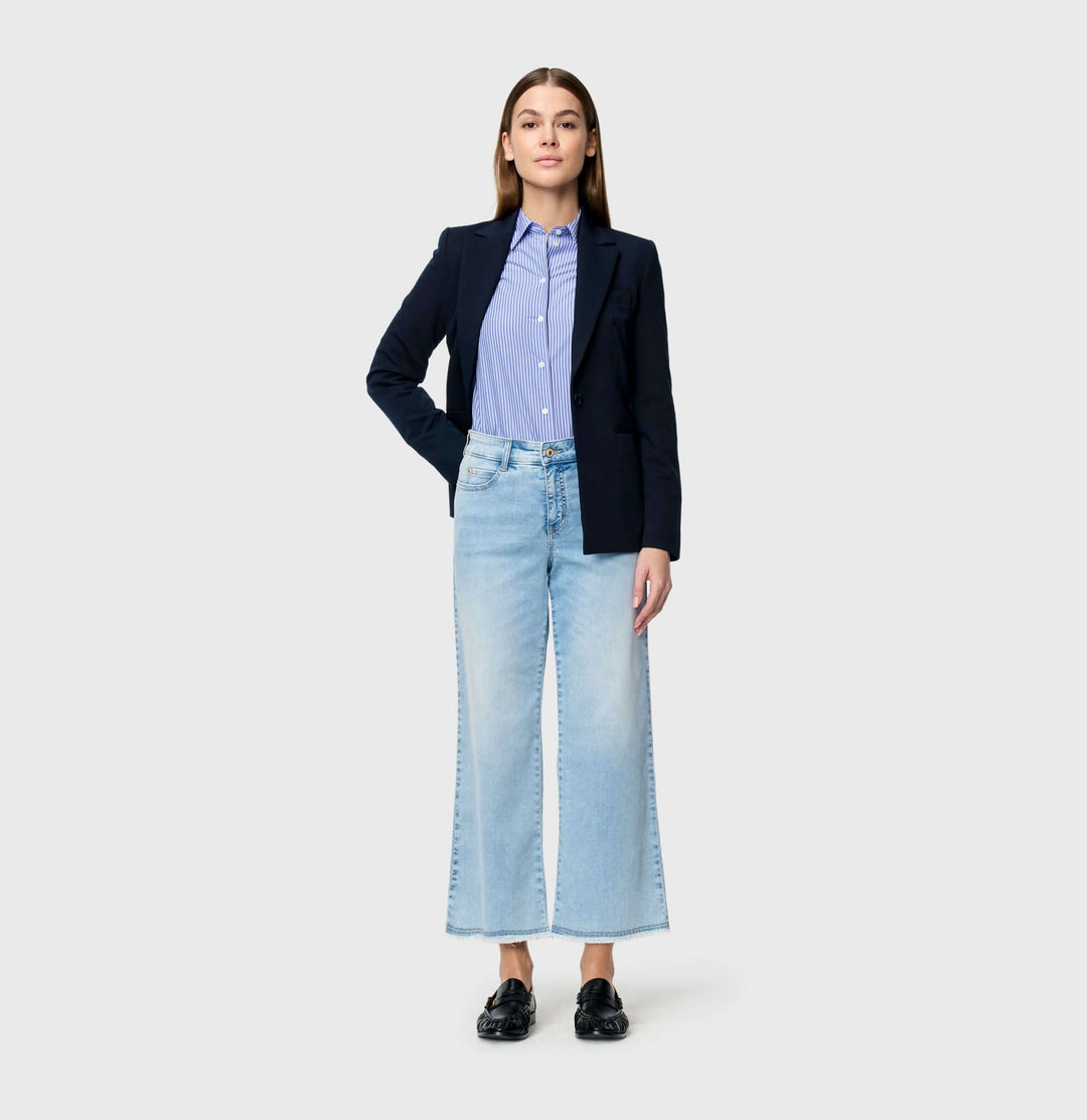 Femme portant des Jeans léger Dream wide cropped, coupe ample, taille haute, combiné avec une veste noire et chemise bleue.