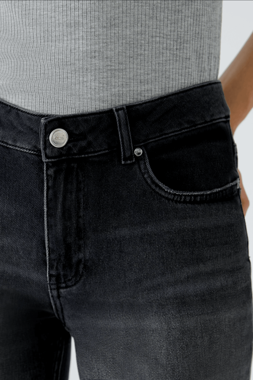 Jean évasé décontracté en denim noir avec détails classiques et couture moderne.