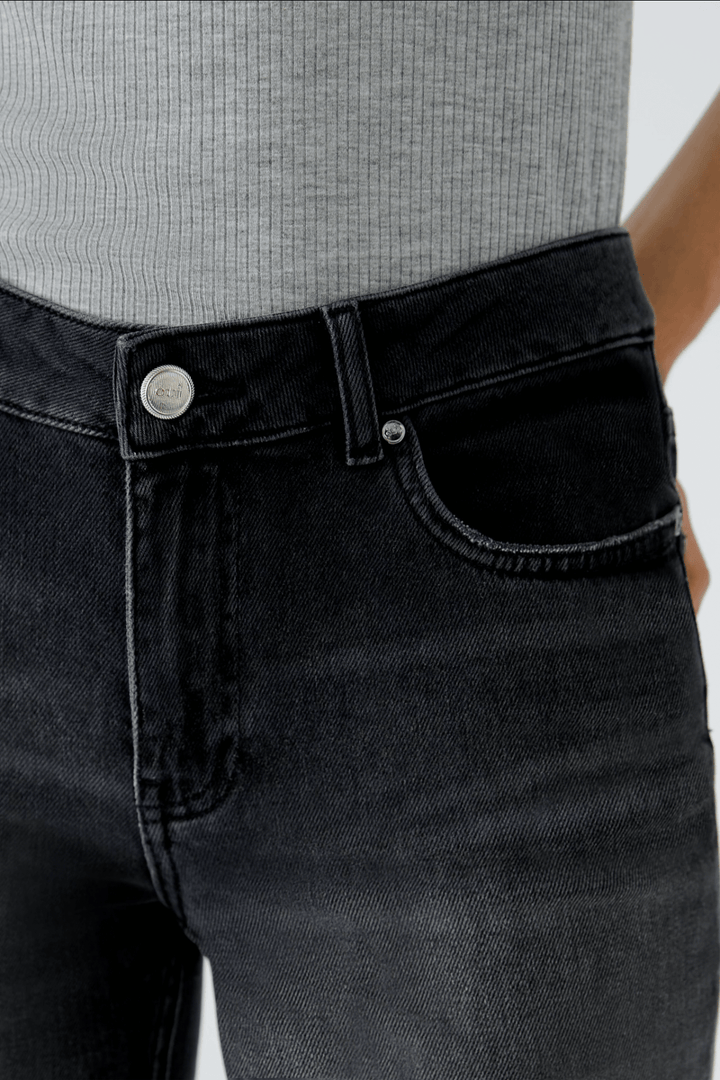 Jean évasé décontracté en denim noir avec détails classiques et couture moderne.