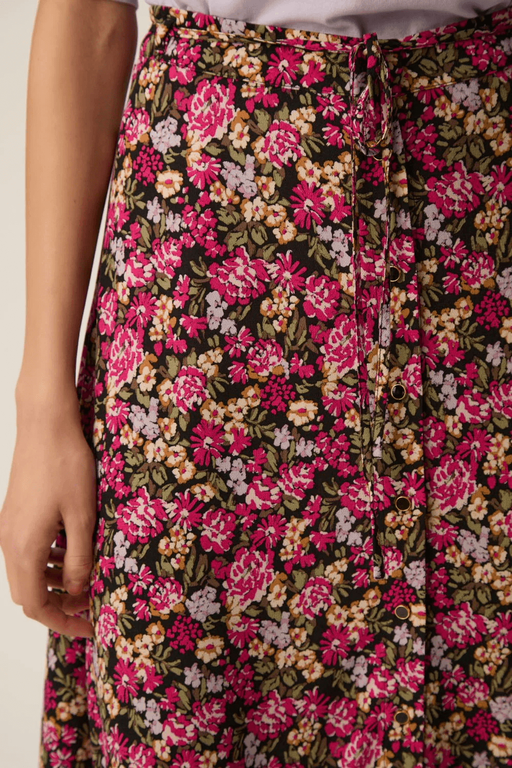 Jupe Elizette longue fluide à taille nouée avec imprimé floral coloré et tissu léger, parfaite pour un style confortable et élégant.