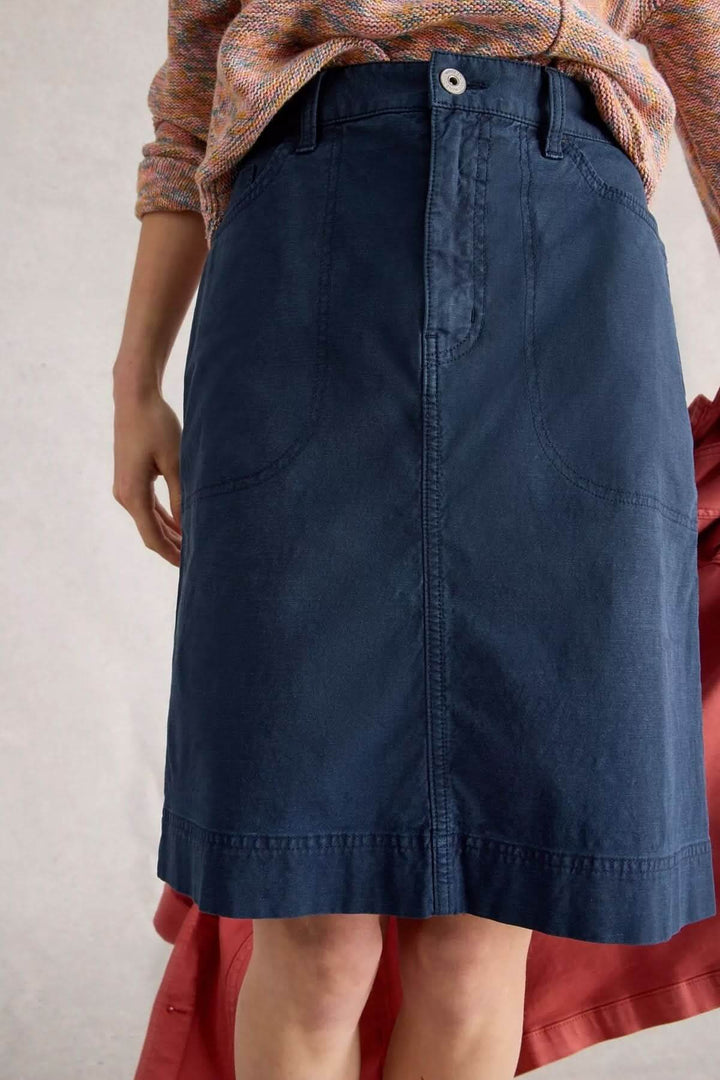 Jupe Tia droite taille haute en tissu souple, parfaite pour un look moderne et décontracté avec un chandail coloré et des baskets.