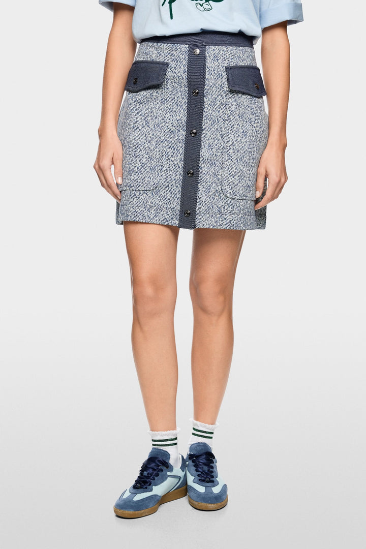 Jupe courte en viscose extensible avec fermeture boutonnée et poches à rabat, allure structurée et inspiration utilitaire moderne.