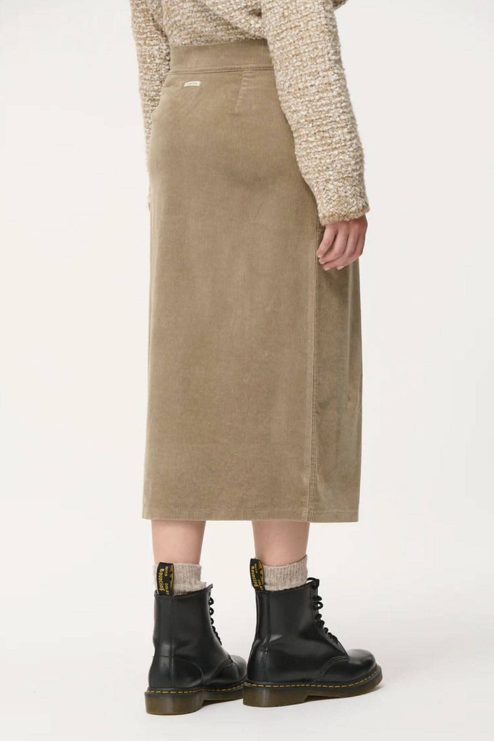 Jupe crayon taille haute en velours côtelé, vue arrière, portée avec des bottines noires.