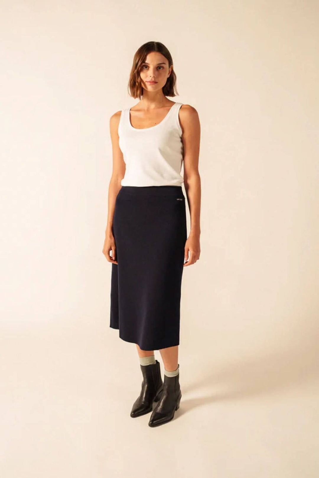 Jupe midi en laine noire porté par un mannequin, coupe droite évasée, style élégant et intemporel pour confort et chaleur.