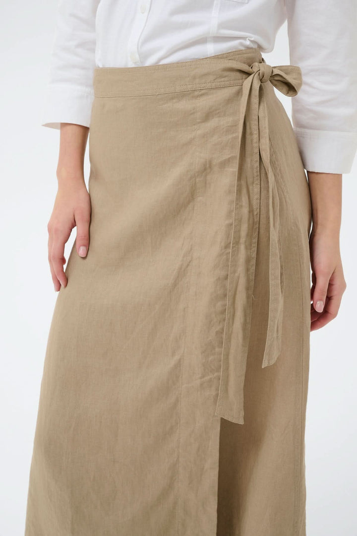 Jupe porte-feuille Arbella beige, design fluide, avec lien à nouer pour un ajustement élégant. Idéale pour un look décontracté et soigné.