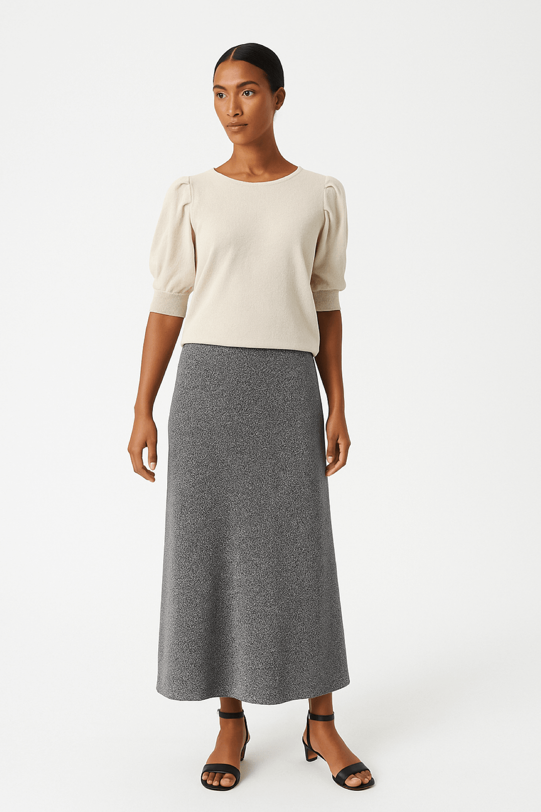 Femme portant la Jupe scintillante Viebe, midi, effet métallisé discret, coupe évasée flatteuse, allure chic pour soirées.