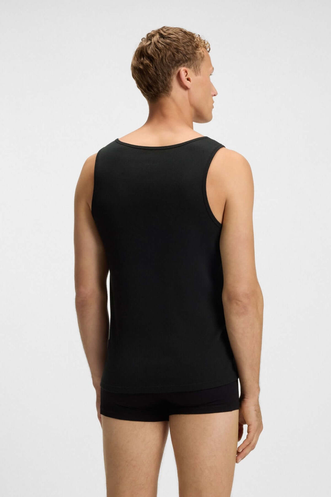 Homme portant un débardeur noir BOSS, vue arrière, design épuré et ajusté, parfait pour le quotidien.