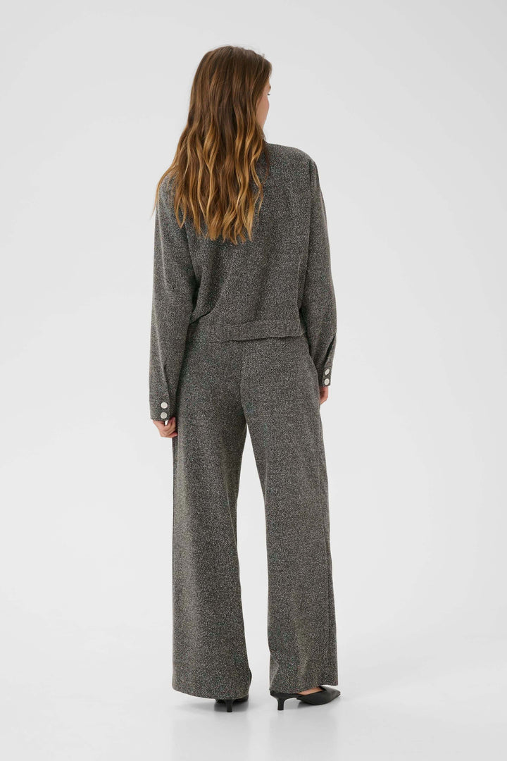 Femme portant un manteau Alba court à poches à rabat et boutons contrastants, vu de dos, mettant en valeur le design moderne et structuré.
