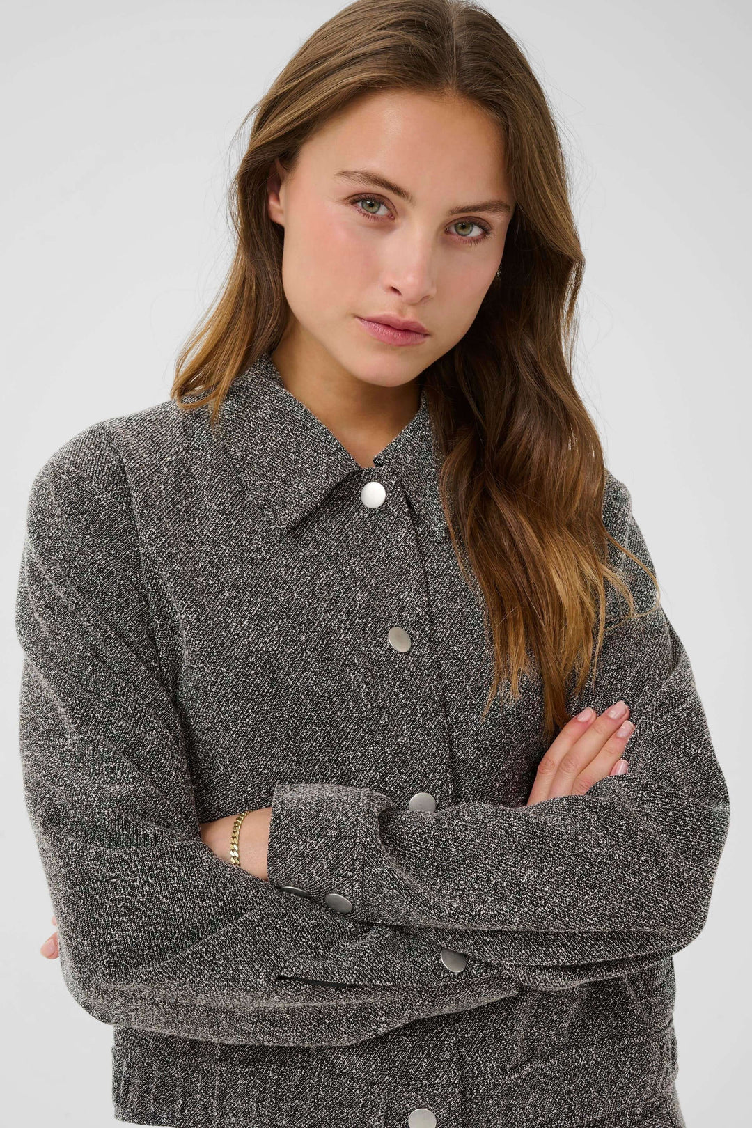 Manteau Alba court à poches à rabat et boutons contrastants porté par un mannequin. Vêtement chic en tissu texturé idéal pour l&
