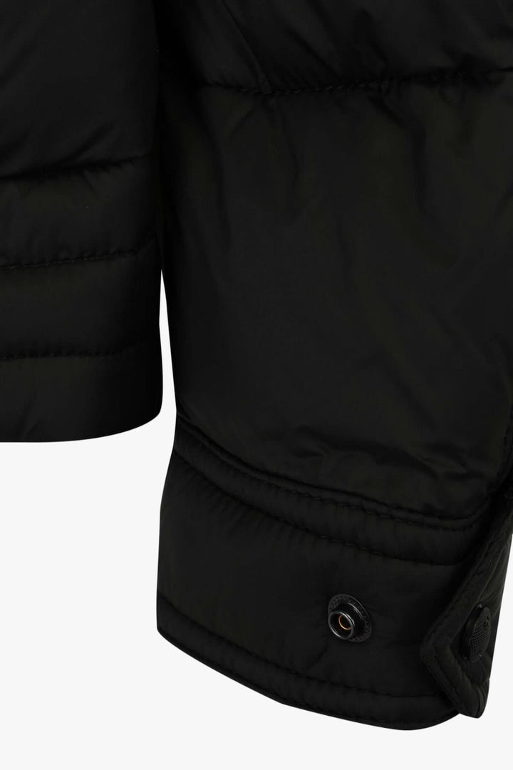 Détail de la manche d'une veste matelassée noire BOSS, mettant en avant le tissu et le bouton-pression.