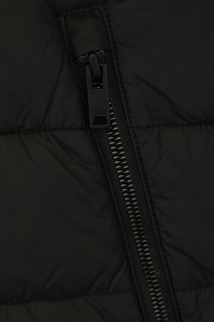 Zoom sur la fermeture éclair d'une veste matelassée BOSS, couleur noire, alliant confort et style.
