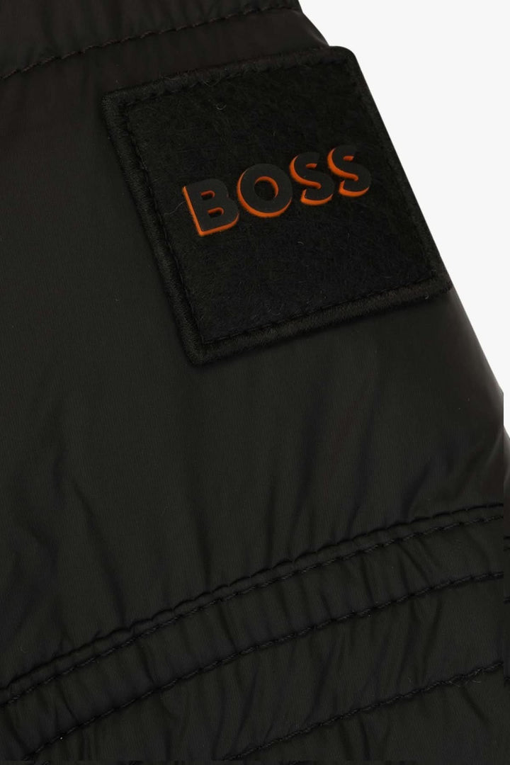 Détails du manteau Boss avec logo en relief sur l'empiècement matelassé.