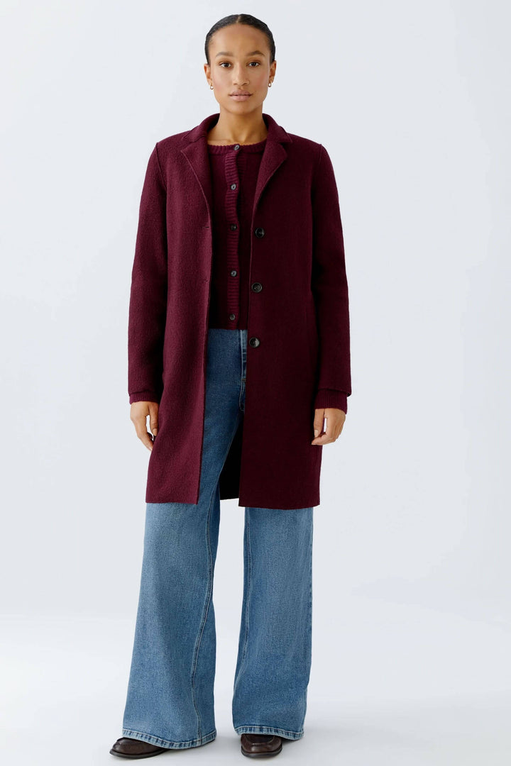 Manteau Mayson bordeaux élégant avec coupe longue, porté avec jean pour un look chic et décontracté, idéal pour mi-saison et hiver.