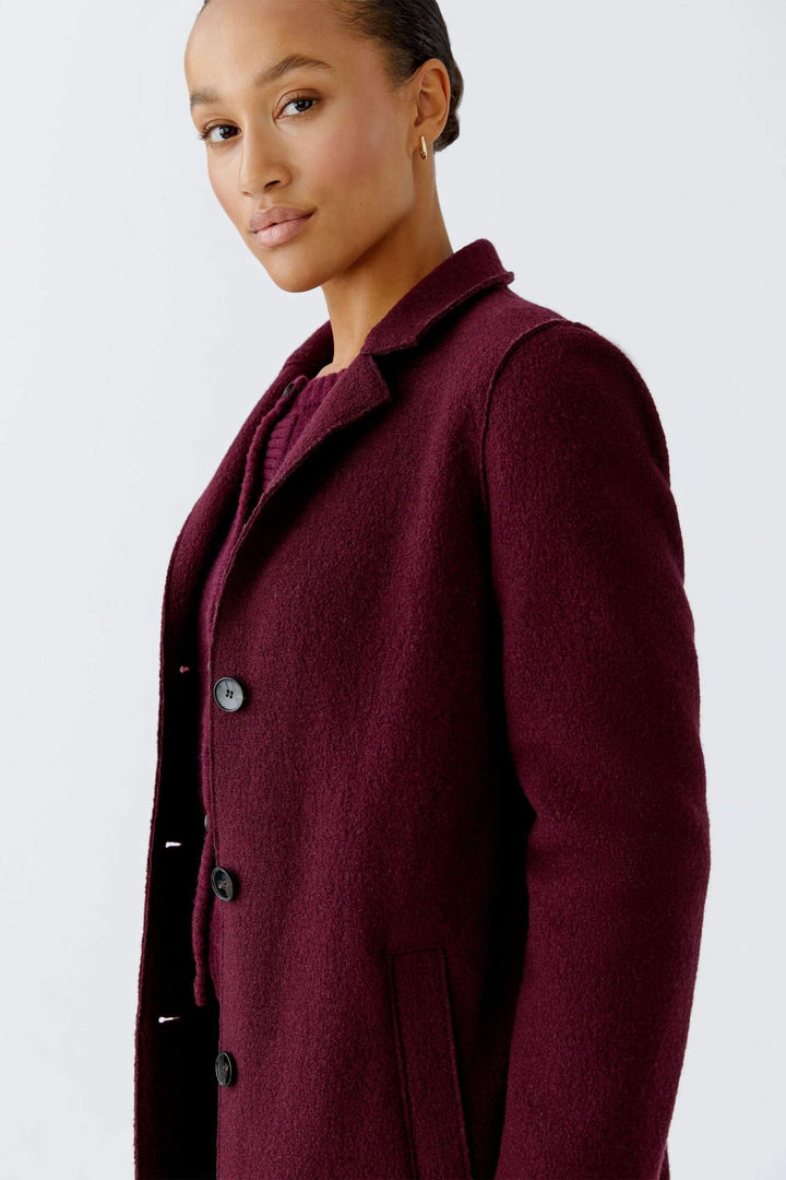 Femme portant le Manteau Mayson bordeaux pour style chic et décontracté avec col tailleur et coupe longue idéale pour l&