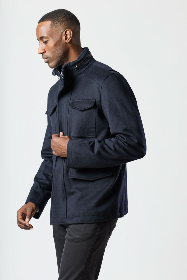 Manteau en laine à quatre poches, homme élégant en veste structurée, col montant avec capuche, style smart-casual.
