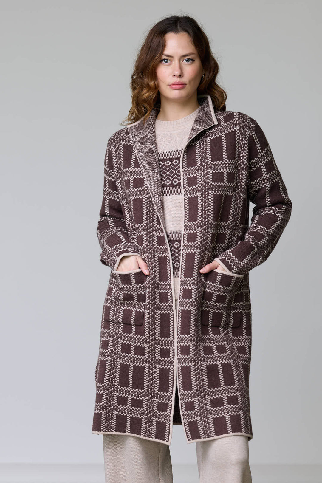 Manteau en tricot à motif géométrique avec col ouvert et poches plaquées, coupe droite, longueur mi-cuisse pour un style moderne.