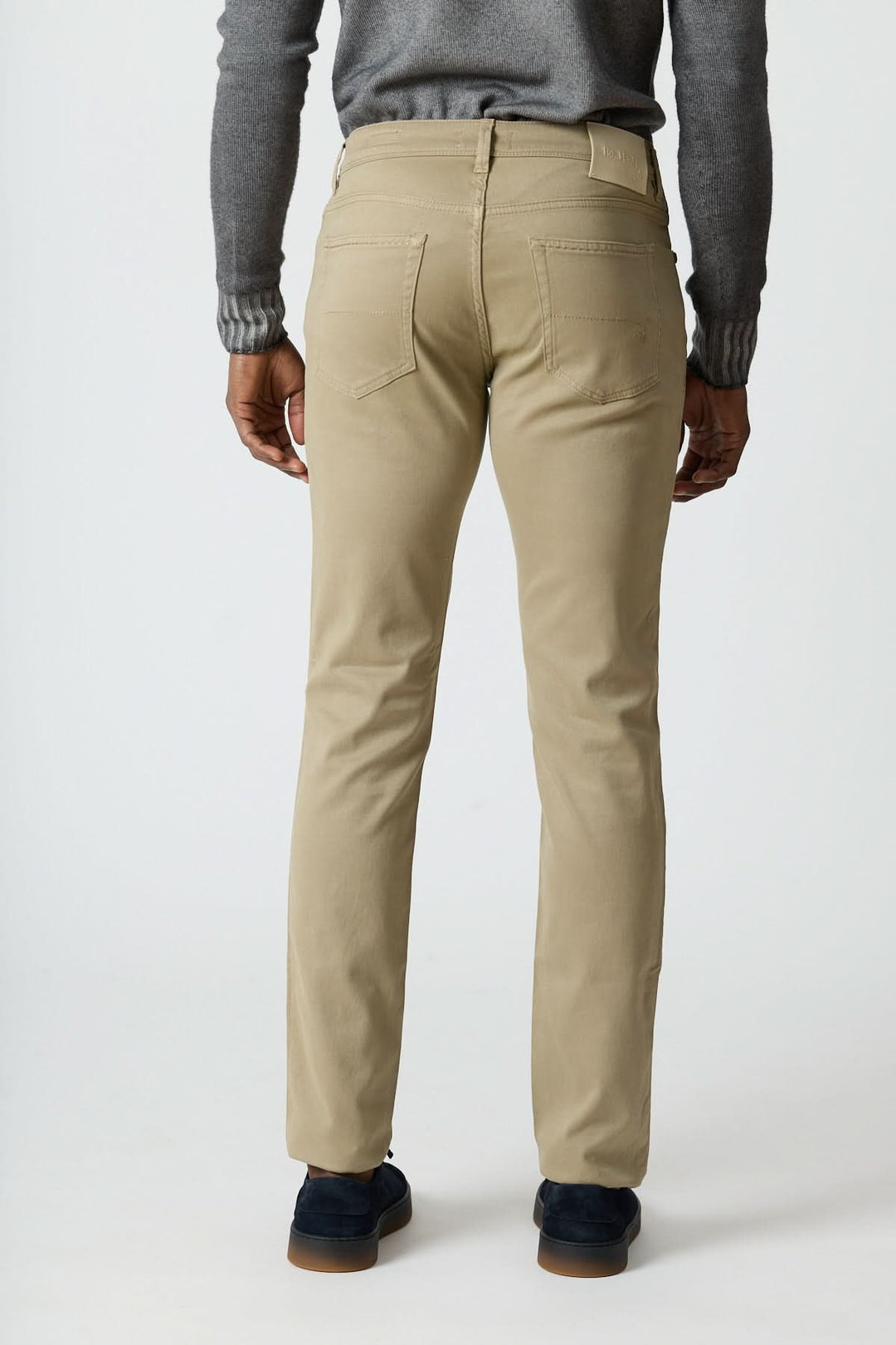 Pantalon 5 poches en sergé coton-lyocell beige, porté de dos, mettant en avant sa coupe ajustée et son élégance italienne décontractée.